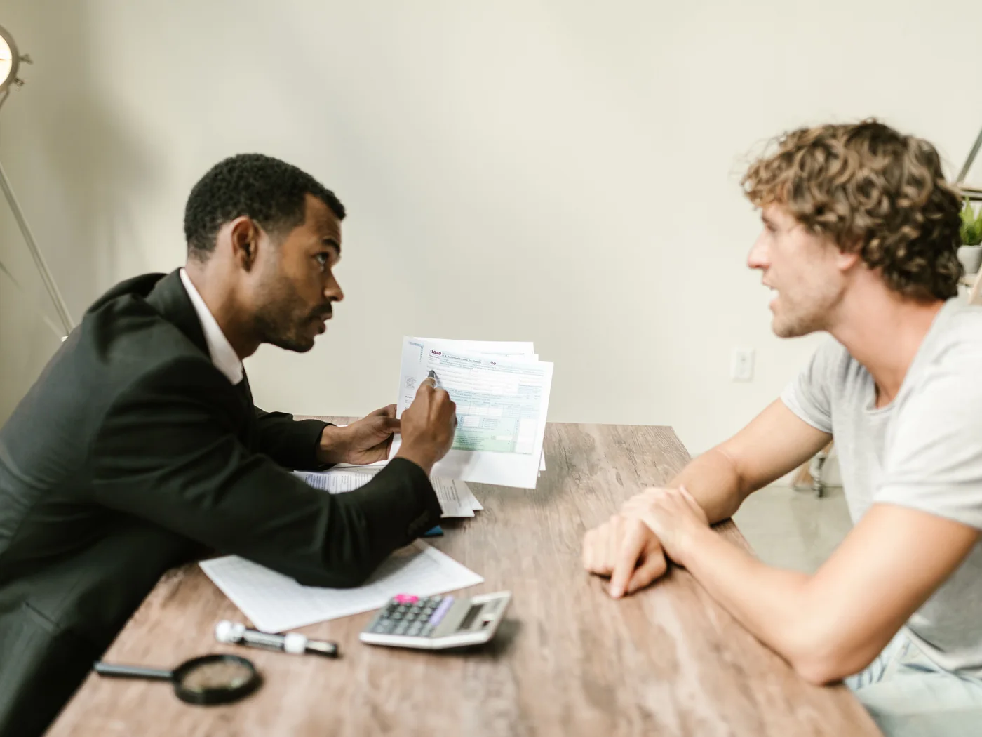 Consultor financeiro explicando documentos a um cliente no escritório.
